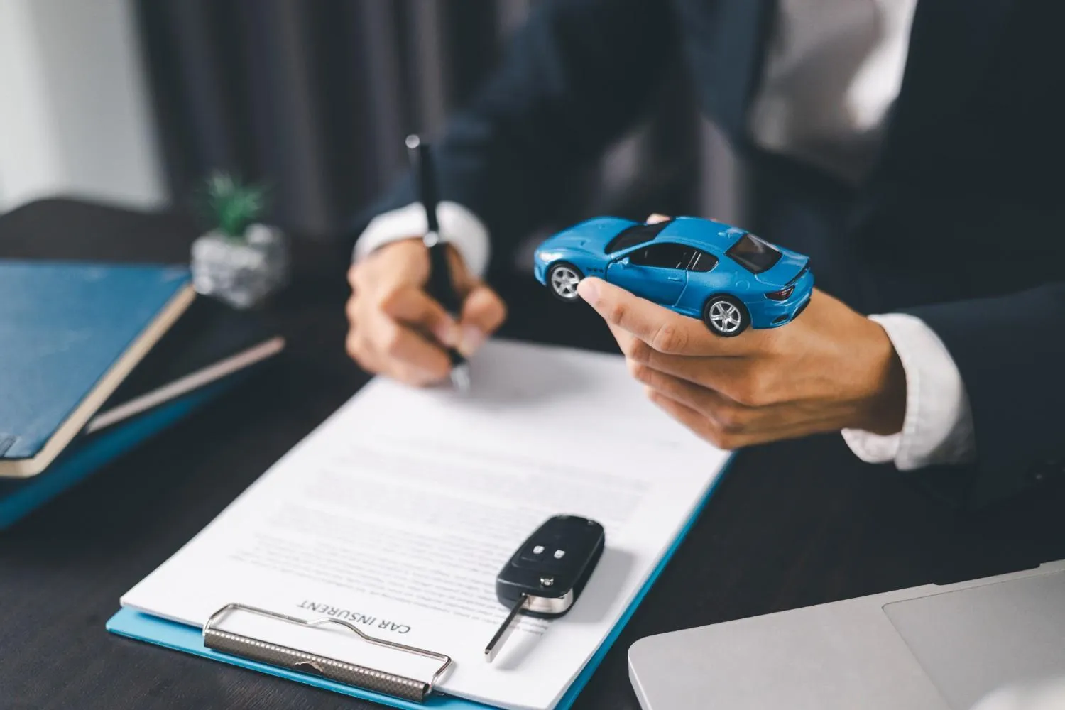 Signing a car policy beside a set of keys